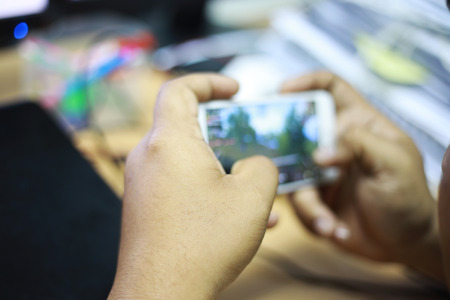 Closeup handsome guy playing mobile gamesの写真素材