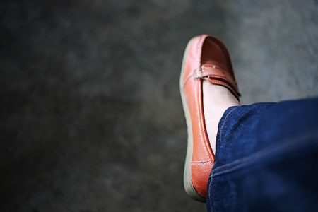 Women's shoes wear orange shoes and jeans, copy space and dark backgroundの写真素材