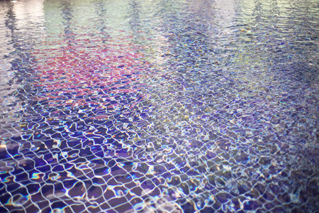 Water surface with waves on water surface wave effect, can see the blue square tiles at the bottom of the pool.の写真素材