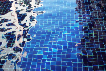 Water surface with waves on water surface wave effect, can see the blue square tiles at the bottom of the pool.の写真素材