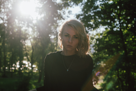 Portrait of a blond woman walking in a park on a warm sunny day