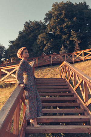 Woman standing on the stairs in urban eco park on the sunsetの写真素材