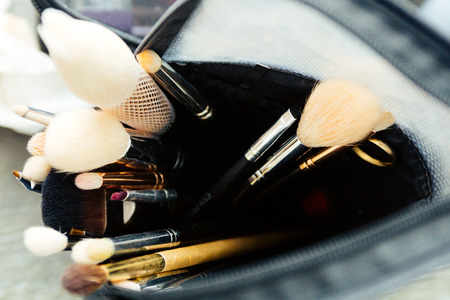 An assortment of new makeup brushes in a makeup artist's kit