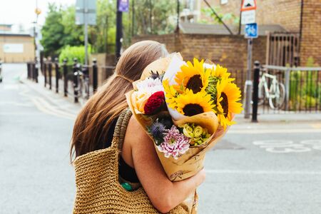 London/UK - July 22 2018: Young woman with bunch of flowers purchased on the Columbia Road Flower Market in the East of London, UKのeditorial素材