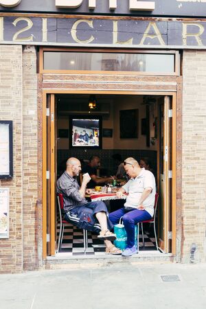 London, UK - July 22, 2018: two man talking in a street cafe on the Brick Lane in London, UKのeditorial素材