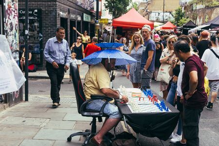 London, UK - July 22, 2018: Man playing chess with tourists on the Brick Lane, Londonのeditorial素材