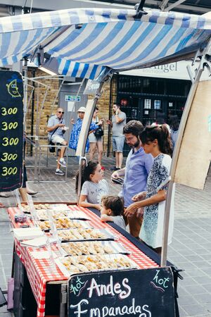 London, UK - July 23, 2018: Young family with two kids choosing pastery on the Greenwich Market in Londonのeditorial素材