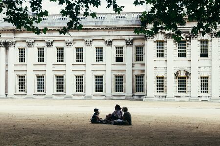 London, UK - July 23, 2018: tourists sitting on the withered grass near Old Royal Naval College in Greenwich, London, UKのeditorial素材