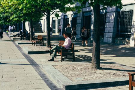London, UK - July 23, 2018: businessman resting on a bench on a city street on a warm sunny day in Londonのeditorial素材