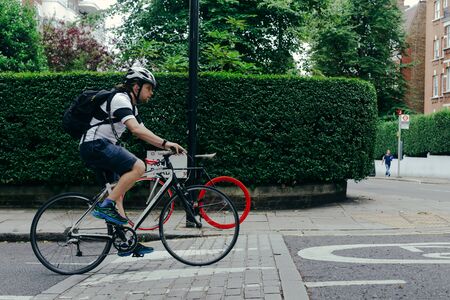 London, UK - July 30, 2018: man riding a bike on London streetのeditorial素材