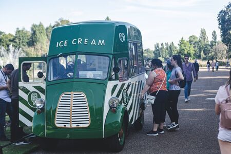 London/UK - 22/07/19: women buying soft serve ice cream in Ice cream van in a park. Ice cream vans are often seen parked at public events, near parks, beaches or other areas where people congregateのeditorial素材
