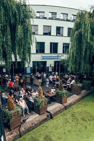London/UK - July 17, 2019: people resting at The Ice Wharf Pubâs outdoor seating area near Regent's Canal opposite the Camden Market, a fourth-most popular visitor attraction in Londonのeditorial素材