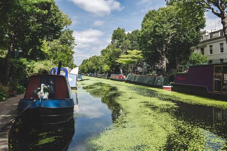 London/UK - 17/07/2019: narrowboats moored along the Regents Canal in Little Venice. A narrowboat is a boat of a particular design, made to fit the narrow canal locks of the United Kingdomのeditorial素材