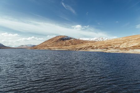 Scenic view of the Loch Glascarnoch and the surrounding hills on a spring sunny day as viewed from...