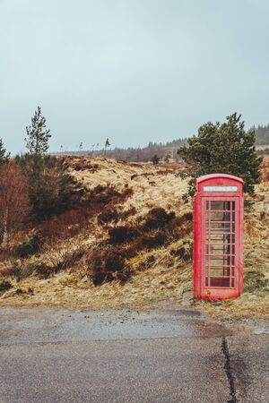 Traditional red telephone box on a side of a road in the Scottish Highlands; "in the middle of nowhere" conceptの写真素材