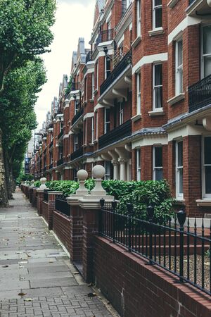 The row of large late Victorian blocks of mansion flats. Typical British houses are the form of medium-density housing that originated in Europe, whereby a row of attached dwellings share sidewallsの写真素材