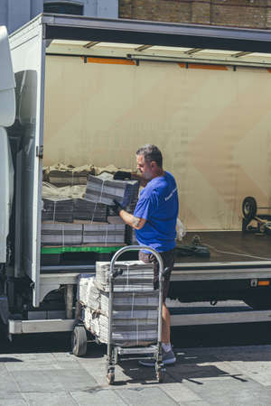 London/UK-1/08/18: man unloading the London Evening Standard at The Quadrant in Richmond. The...