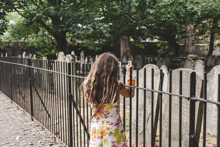 London/UK-22/07/18: a woman is taking a photo of the gravestones in Bunhill Fields, which is a former burial ground in central London. It contains the graves of many notable peopleのeditorial素材