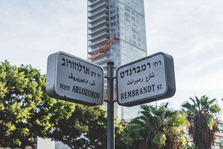 Arlozorov and Rembrandt Street name signs in Tel Aviv, Israel. Street name signs are most often posted at intersections and are usually in perpendicularly oriented pairs identifying crossing streetsのeditorial素材