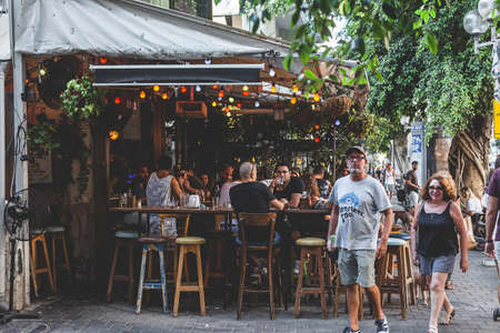 Tel Aviv/Israel-12/10/18: people in an outdoor dining terrace of a local bar on Dizengoff Streetのeditorial素材