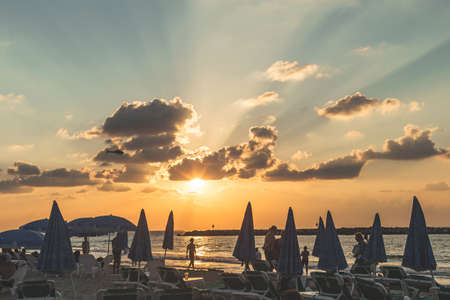 Tel Aviv/Israel-12/10/18: woman playing with her dog among the Sun loungers on a beach in Tel Aviv in the evening just before the sunsetのeditorial素材