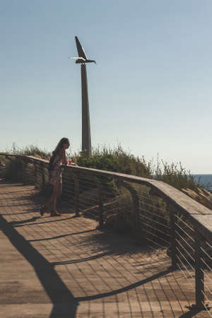 Tel Aviv/Israel-12/10/18: young lonely woman watching into the horizon, leaning on the balustrade in...
