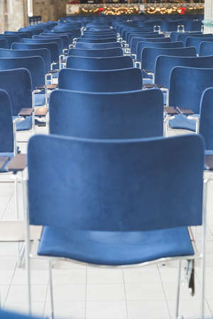 Back view of the rows of blue chairs in a conference hall; no people, selective focusの写真素材