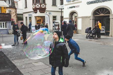 Bad Kissingen/Germany-31/12/18: kids blow on giant soap bubbles on Marktplatz in Bad Kissingen, one of Germany's best-known health resortsのeditorial素材