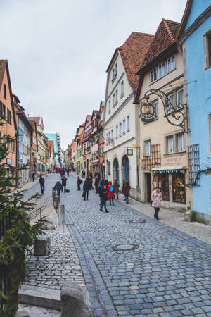 Rothenburg/Germany-1/1/19: people walking past traditional colourful houses in the old town of Rothenburg ob der Tauber. The town is a well known destination for tourists from around the worldのeditorial素材