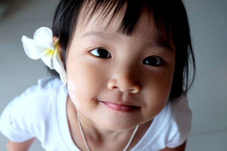 Cute Asian girl  looks at the camera and smiling.の写真素材