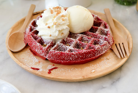 red velvet waffle topped with ice cream and whip cream.の写真素材