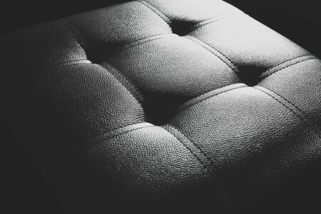 Black leather chair in the shadows.の写真素材