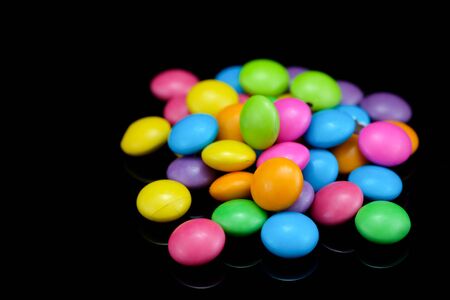Chocolate candy in many colors on a black background.の写真素材