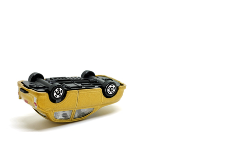 Golden toy cars  Car overturned on a white background, model of the car accidentの写真素材