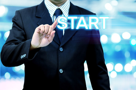 Business man pointing a drag wording start on air management concept in the modern digital age.の写真素材