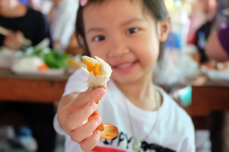 Asian child girl showing crab meat in hand with selective focusの写真素材