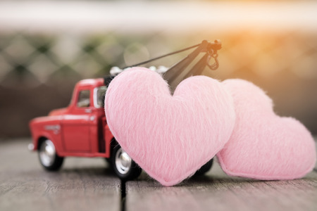 Small red toy car and pink hearts for valentine's Day, Vintage Toneの写真素材