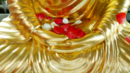 Rose and jasmine on the golden Buddha. Traditions pour water in the Songkran festival in Thailandの写真素材
