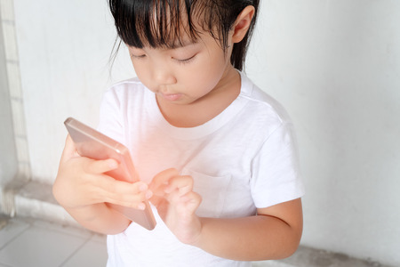 Asian child girls are addictive playing mobile phones, Game Addictionの写真素材