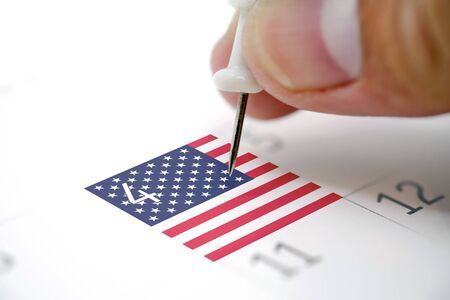 Embroidered white pins on a calendar on the 4th July with USA flag, independence dayの写真素材