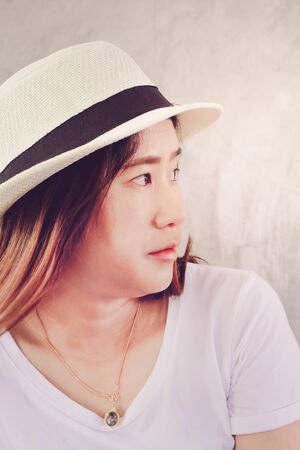 Close-up of face of young asian woman wearing hat lifestyle portraitの写真素材