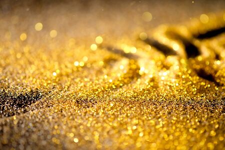 Sprinkle gold shiny dust on a black background with copy spaceの写真素材