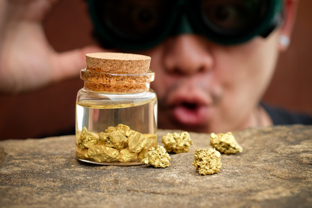 Thief man be stunned looking at gold in the bottle with selective focus