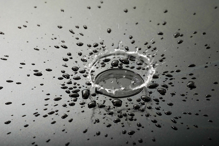 Liquid or water drops splash on the black floor ,abstract backgroundの写真素材