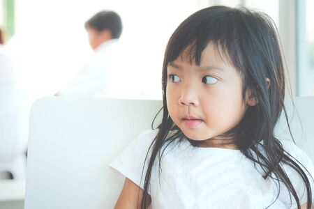 Asian child girl wearing white shirt looking at something with copy spaceの写真素材