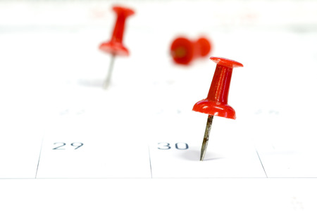 Embroidered red pins on a calendar on the 30th with selective focus