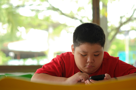 Asian child Boy are addictive playing tablet and mobile phones, Game Addictionの写真素材