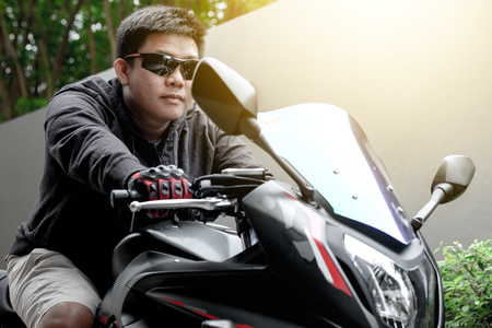 Asian guy wearing sunglasses riding a motorcycleの写真素材