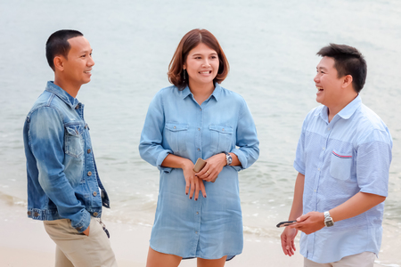 Asian men and women in blue tone are standing by the sea.
