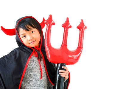 Asian child girl in demon costume holding black and red trident, Happy halloween concept